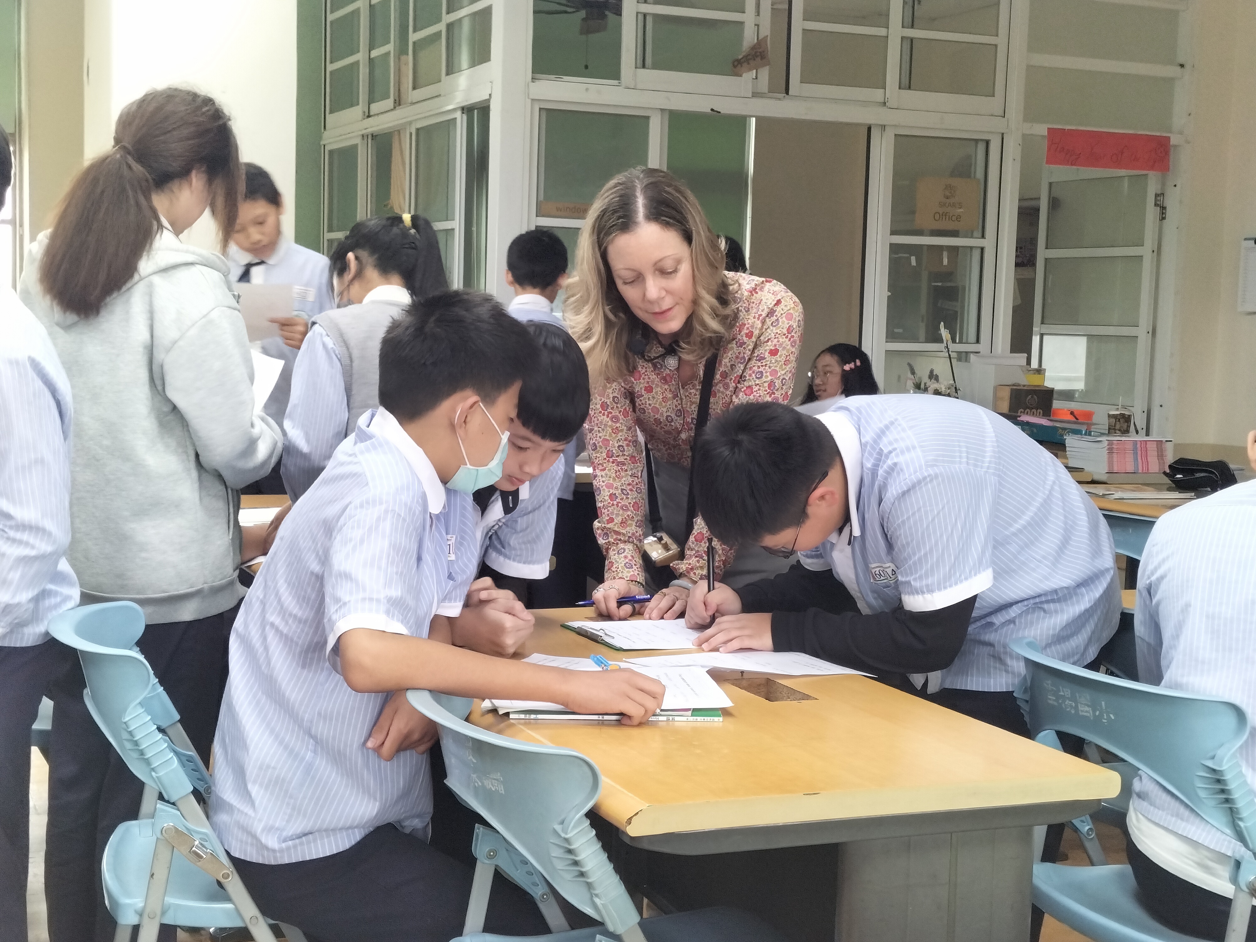老師協助學生完成學習單